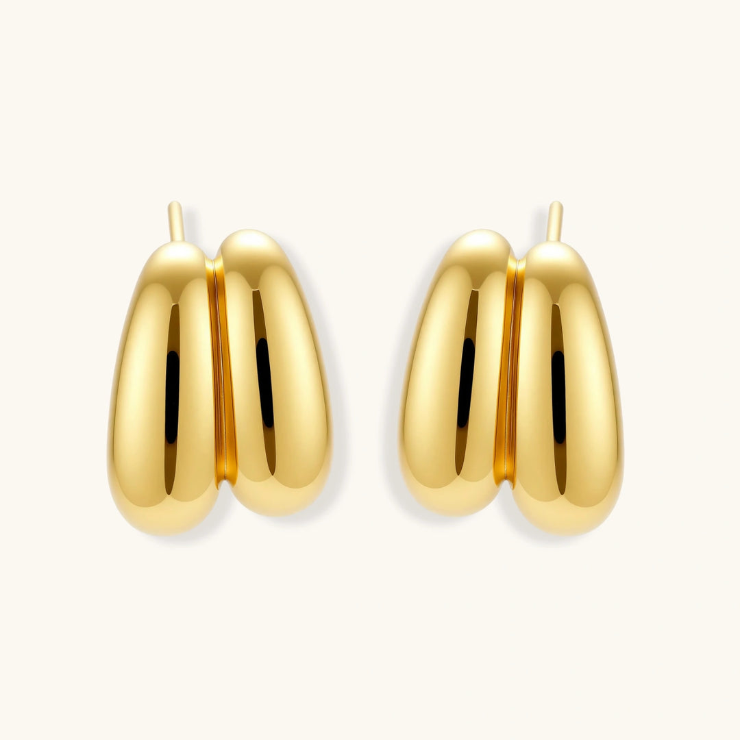 Chunky 18K gold-plated sterling silver hoop earrings with flowing sculptural curves on white background.