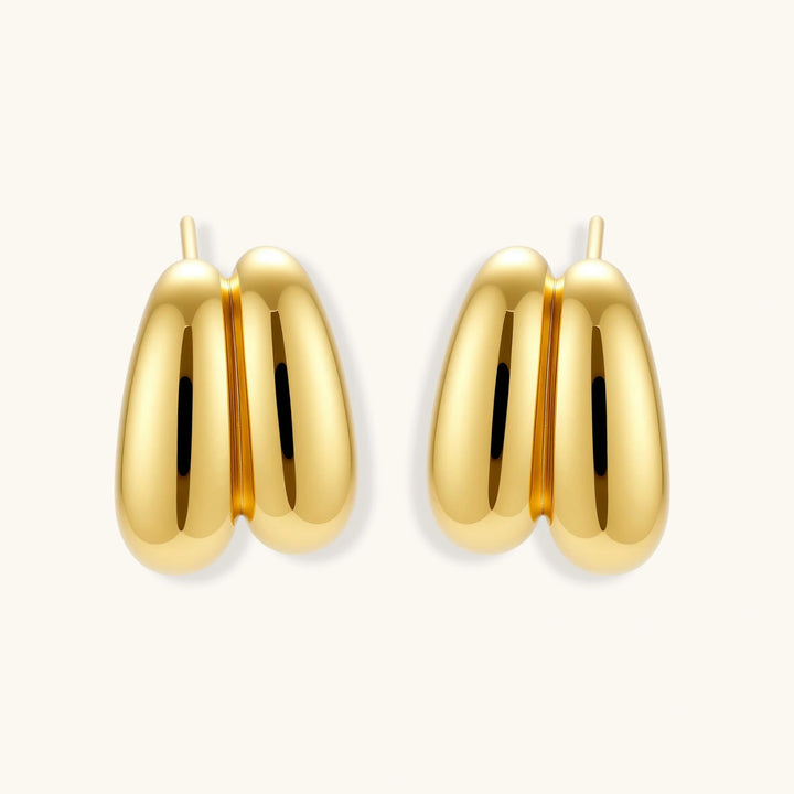 Chunky 18K gold-plated sterling silver hoop earrings with flowing sculptural curves on white background.